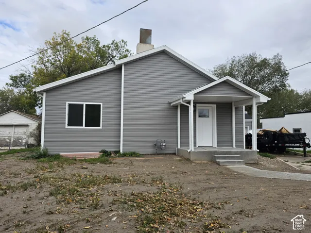 Gray siding exterior with white trim, covered front porch, and concrete steps