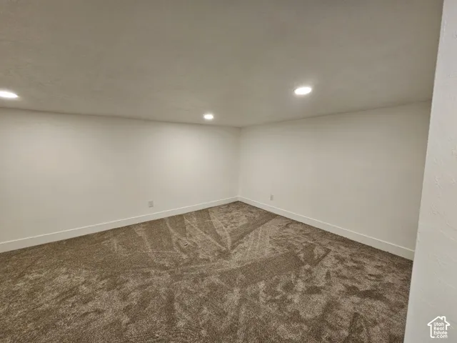 Recessed ceiling lighting illuminates the wall-to-wall carpet and neutral wall finishes