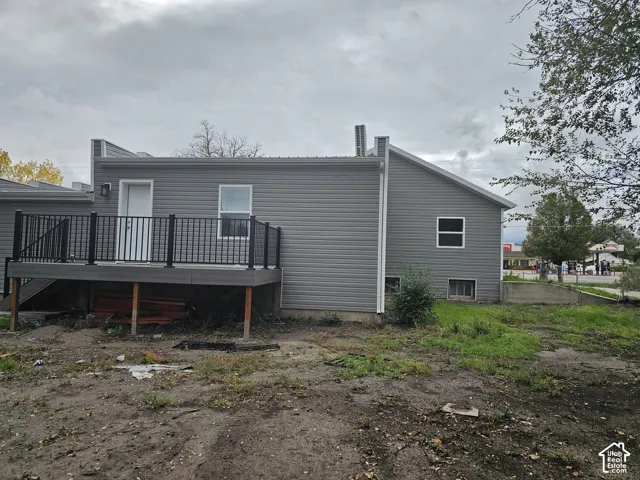 Exterior featuring gray siding, a composite deck with black railings, and multiple windows
