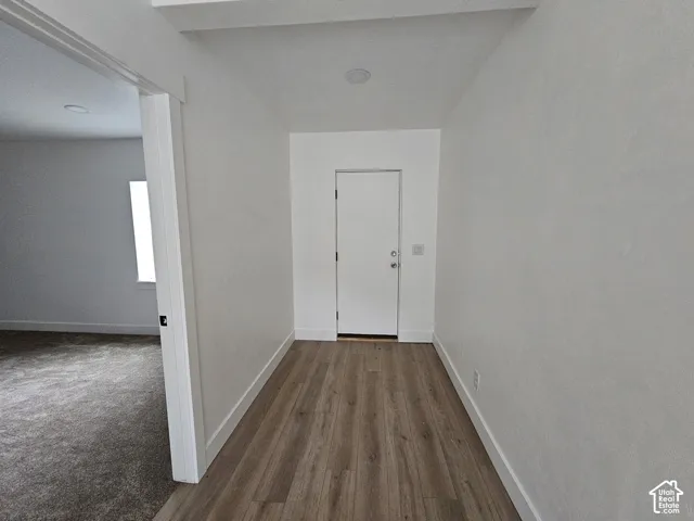 exit to back yard Wood-finish flooring, white door, recessed lighting, white walls, and white trim