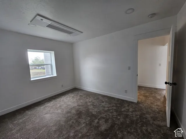 Plush carpeted flooring, a single window, white trim, recessed lighting, and a ceiling-mounted HVAC unit