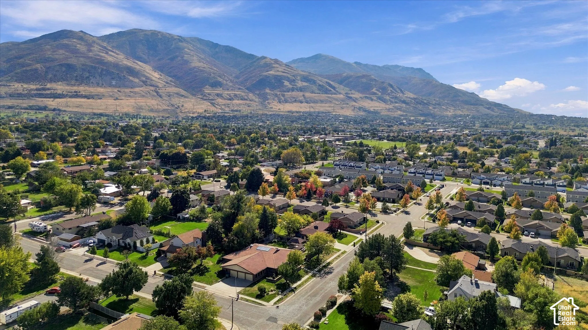 Aerial perspective showcasing the expansive community, mature trees, and mountainous terrain