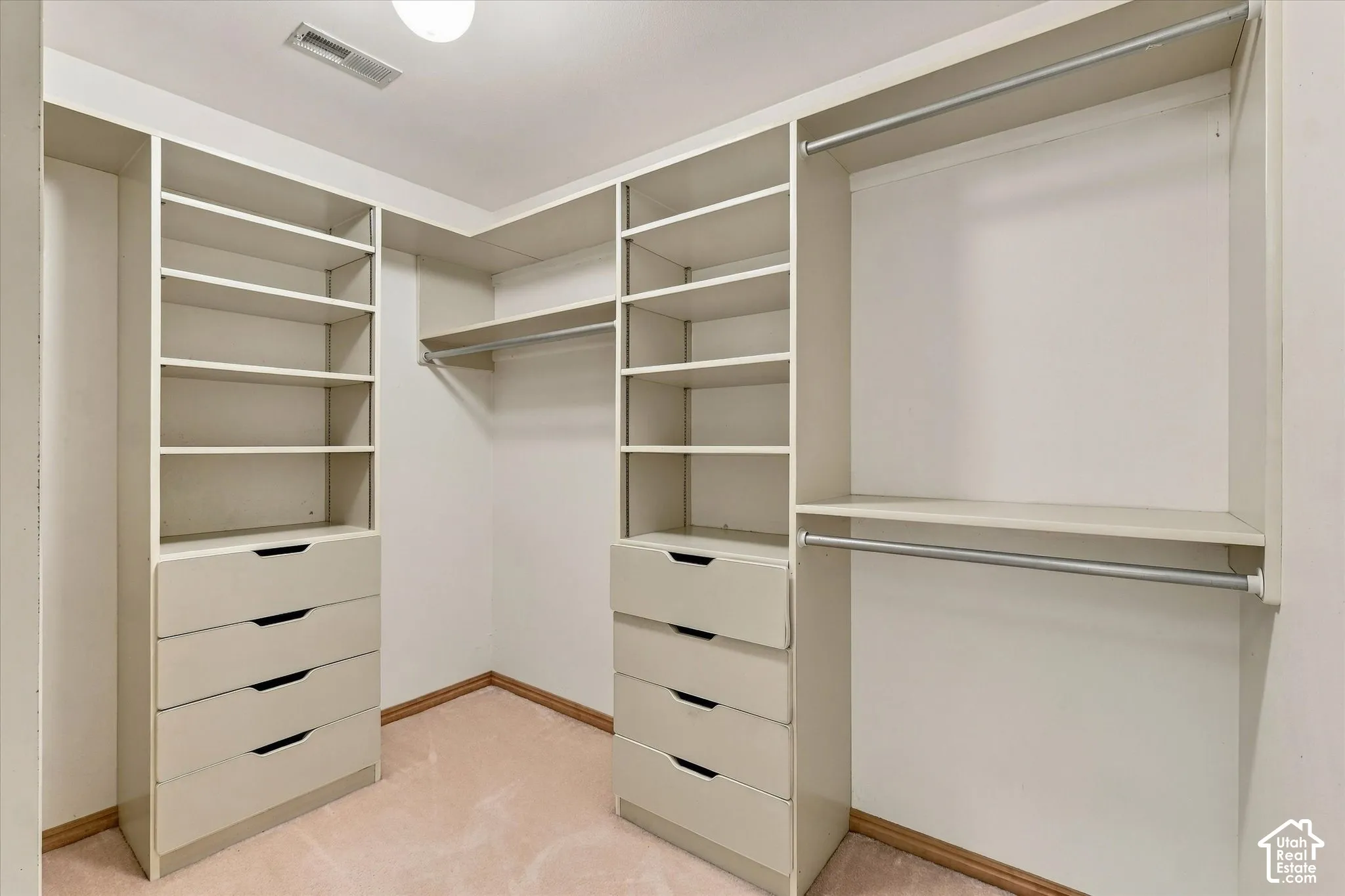 Built-in custom closet system with hanging rods, shelving, and drawer storage