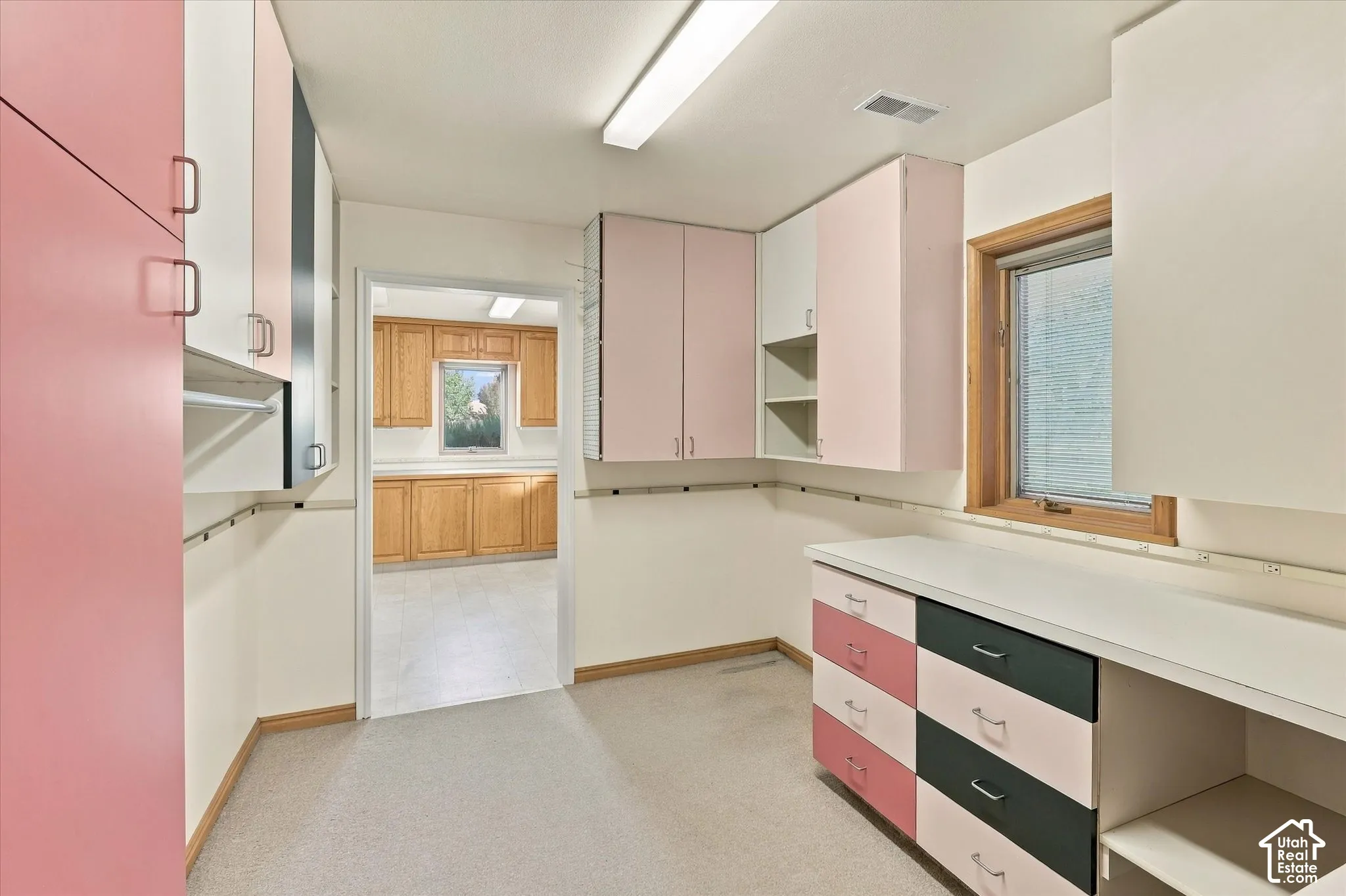 Great craft room storage with built-in cabinetry with ample storage, integrated workspace, and window for natural light
