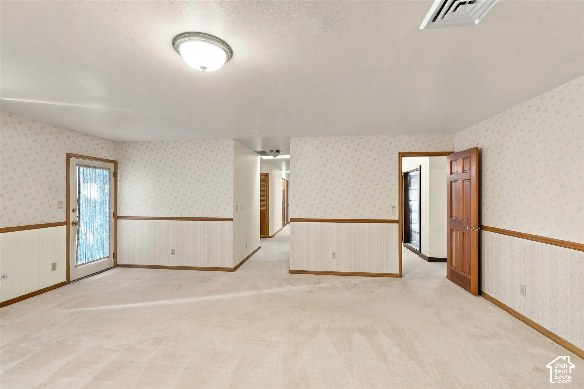 Spacious open floor plan with neutral wall finishes, wood-trim architectural detailing, and recessed ceiling lighting