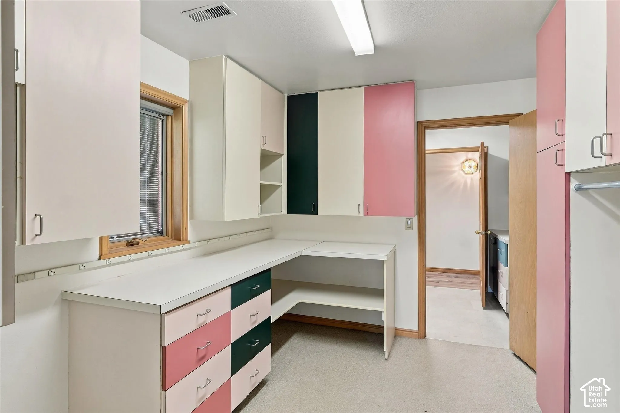 Built-in cabinetry with varied finishes, extensive countertop space, and an integrated work surface with many power outlets.