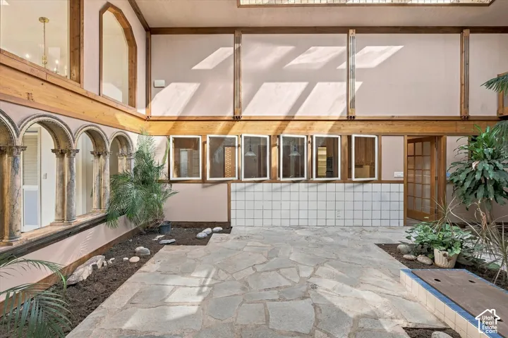 Stone tile flooring with high ceilings and walls accented with wood