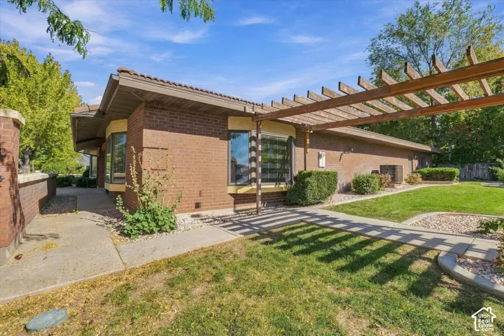 Brick exterior with a tile roof, featuring a wood pergola and bay windows