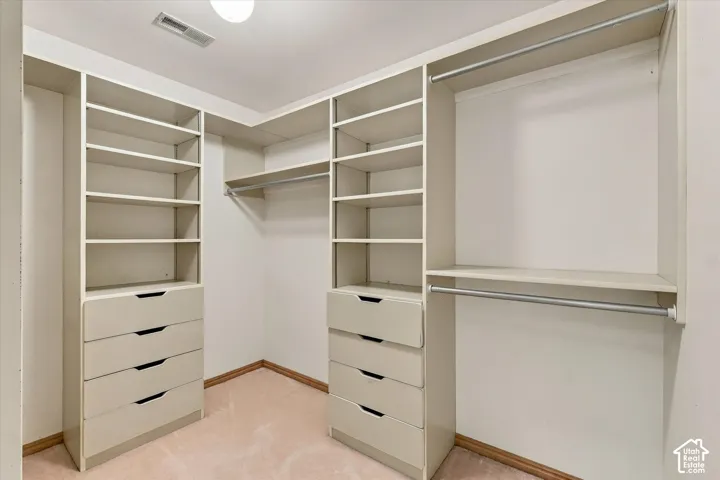 Built-in custom closet system with hanging rods, shelving, and drawer storage