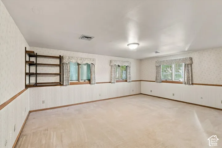 Spacious primary bedroom featuring three windows and built in shelving