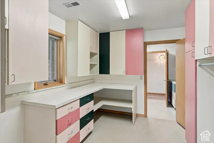 Built-in cabinetry with varied finishes, extensive countertop space, and an integrated work surface with many power outlets.
