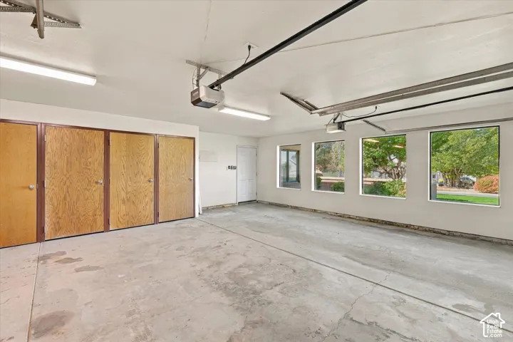 Attached garage featuring painted walls and multiple storage closets