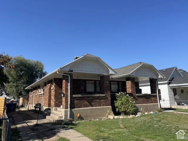 Brick exterior with multiple gabled rooflines, covered entry porch, and mature landscaping