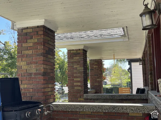 Brick columns supporting a painted wood-plank porch ceiling with integrated outdoor lighting