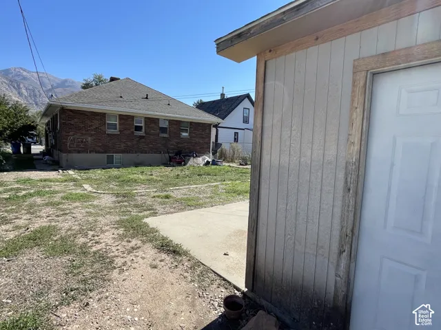 Detached structure with panel siding, a shingle roof, and a panel door