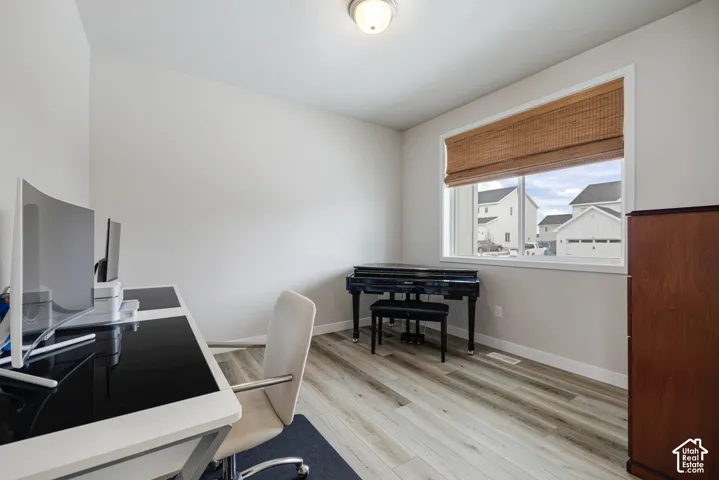 Wood-finish flooring, neutral wall paint, and a single window with blinds