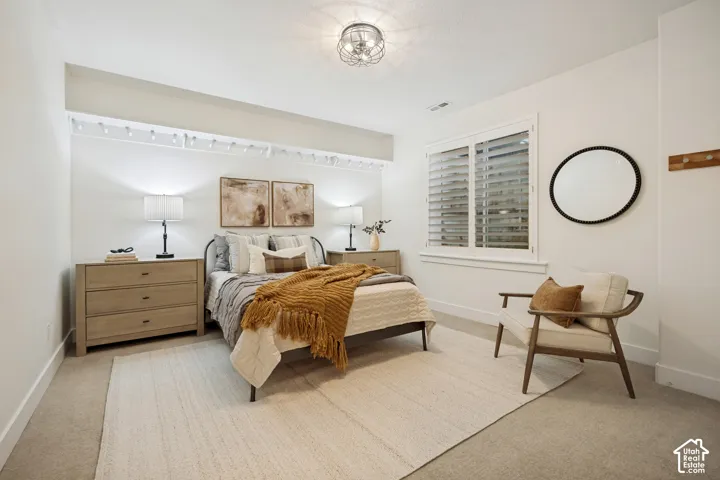 Recessed lighting, window with plantation shutters, ceiling-mounted light fixture, light-toned carpet flooring, and white wall finishes