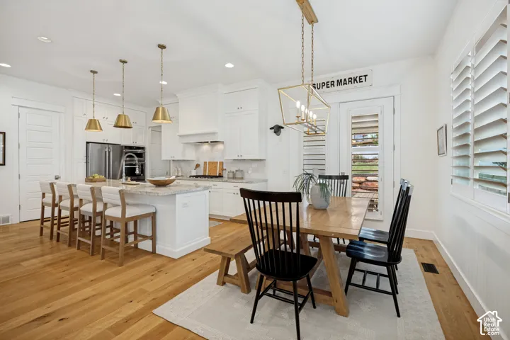 Gourmet kitchen with white cabinetry and stainless steel appliances
