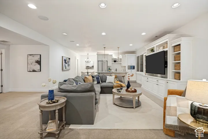 Open-concept living space featuring recessed lighting, a built-in entertainment center, and carpet flooring