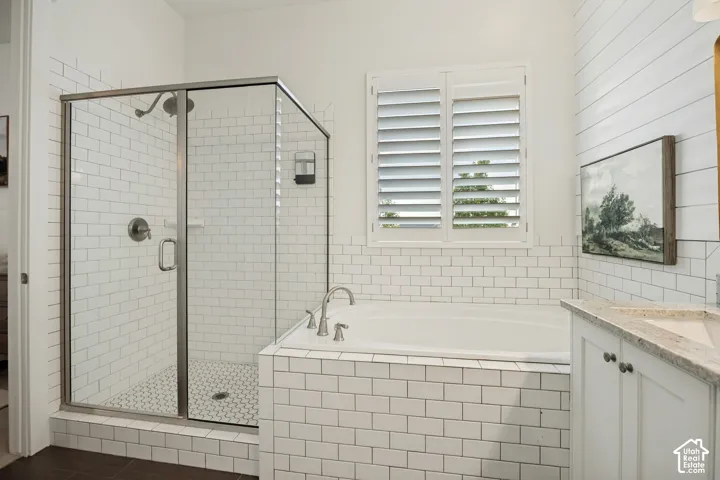 Shower enclosure with glass paneling, subway tile surround, and mosaic tile flooring