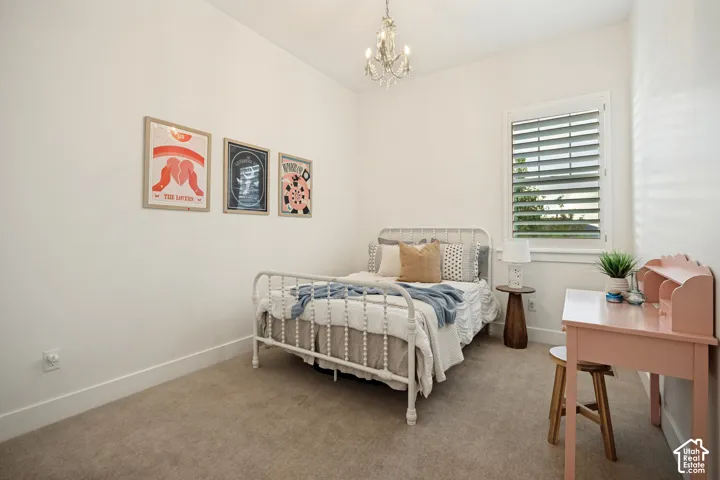 Recessed window with plantation shutters, overhead chandelier, and neutral wall paint
