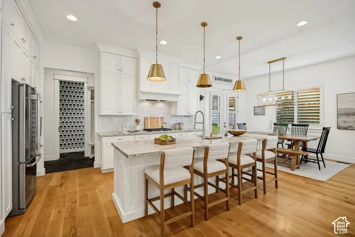 Gourmet kitchen with white cabinetry, stainless steel appliances, and a central island with a granite countertop