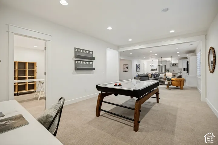 Open-concept living space with recessed lighting and neutral carpeting