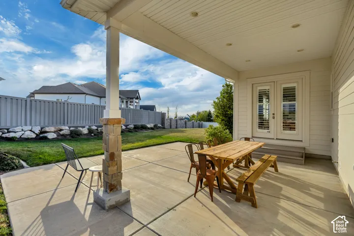 Covered patio featuring a stone-clad column, recessed lighting, and direct access through double doors
