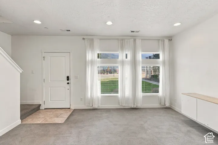 Entry area with tile flooring and a white door with dark hardware