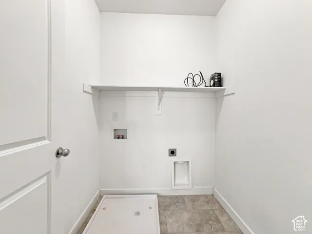 Utility connections with a built-in shelf, durable flooring, and a white paneled door