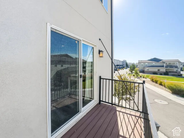 Balcony off kitchen featuring wood-finish decking and black metal railing