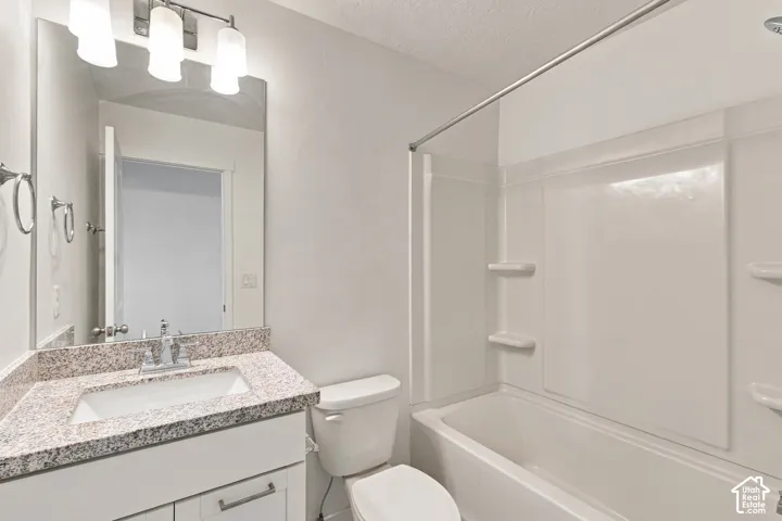 Vanity with granite countertop and undermount sink, chrome faucet, and rectangular mirror