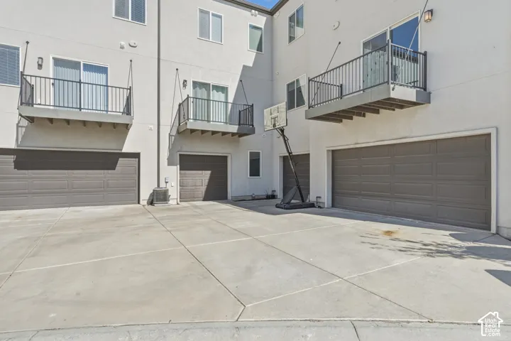Concrete driveway with three attached garages, two featuring single doors and one with a double door