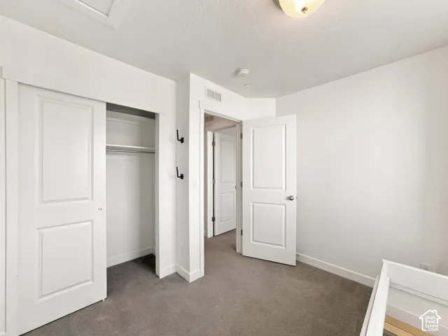 Recessed panel closet doors, built-in closet rod, wall-mounted coat hooks, flush-mount ceiling light, and neutral wall paint