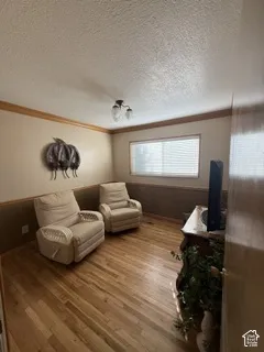 Hardwood flooring, crown molding, wall-mounted light fixture, window with blinds