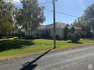 Single-story residence with a pitched roof, light-colored siding, and a chimney