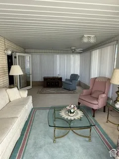 Enclosed sunroom with brick wall accents, multiple ceiling fans, and French doors