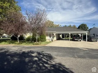 Single-story residence featuring a carport, concrete driveway, and a shingle roof