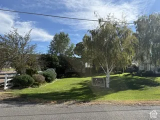 Expansive front lawn with mature trees and established landscaping