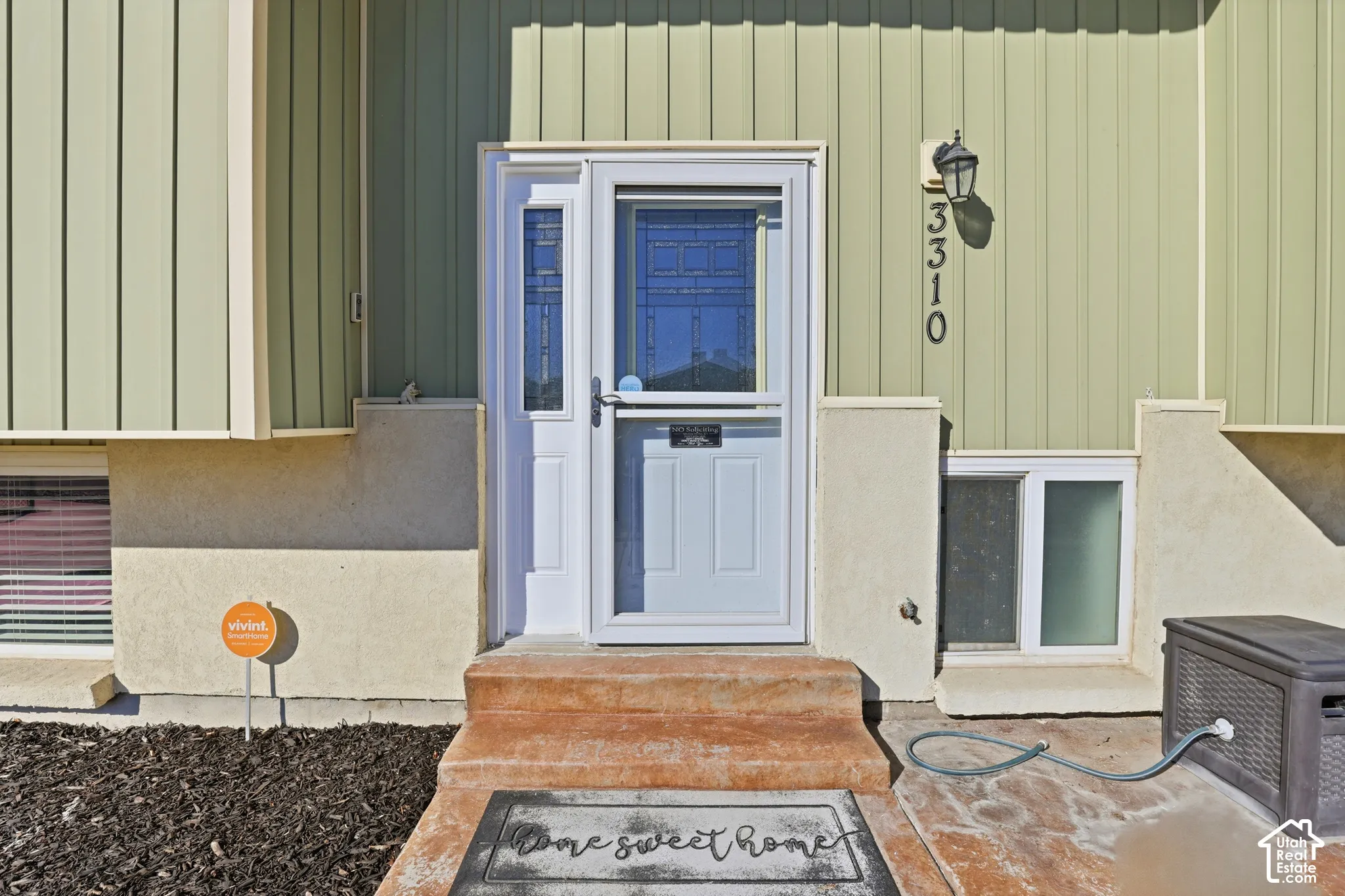 Entry door with sidelight, storm door, and exterior lighting fixture