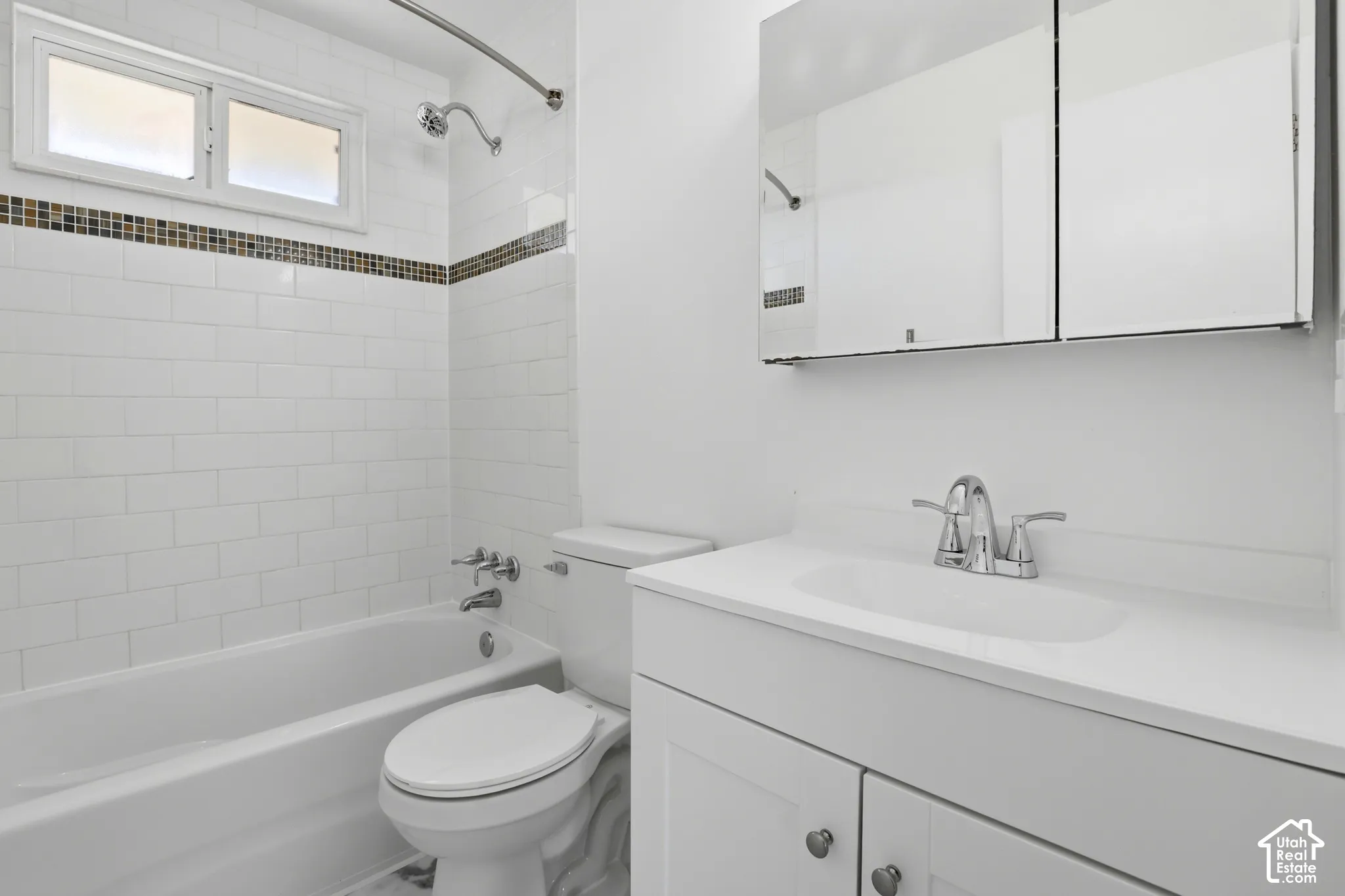 White subway tile tub surround with mosaic accent