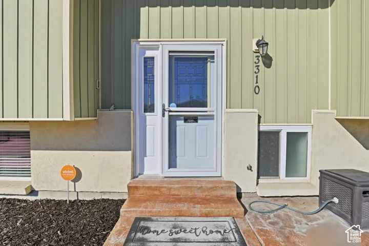 Entry door with sidelight, storm door, and exterior lighting fixture