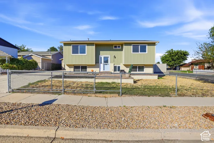 Two-story exterior with light green vertical siding and a tan foundation