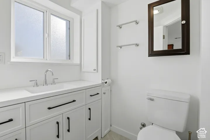 White vanity with integrated sink, chrome faucet, and black hardware