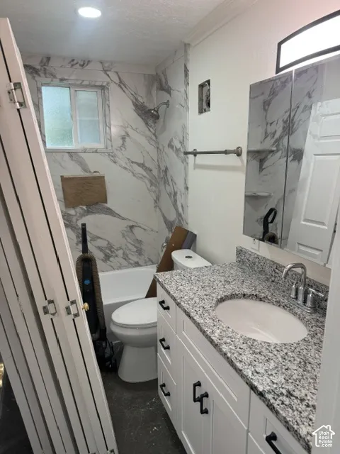 White vanity with black hardware, granite countertop, undermount sink, and chrome faucet