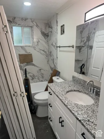 White vanity with black hardware, granite countertop, undermount sink, and chrome faucet