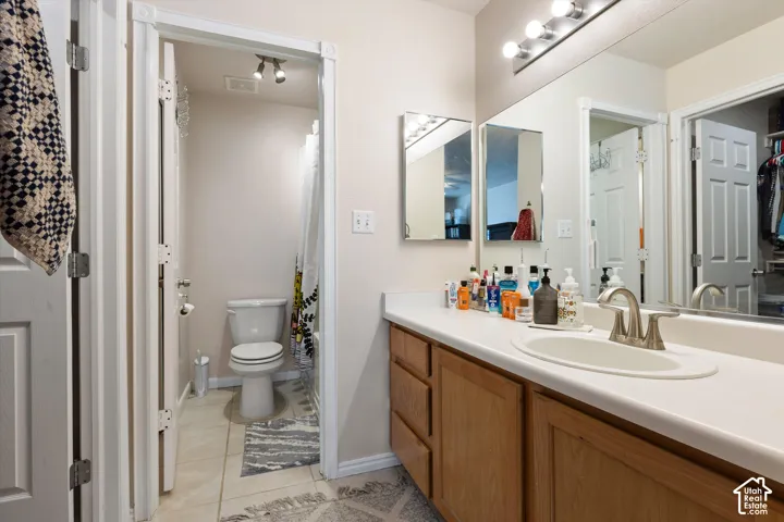 Bathroom vanity featuring a single basin sink and wood-finish cabinetry