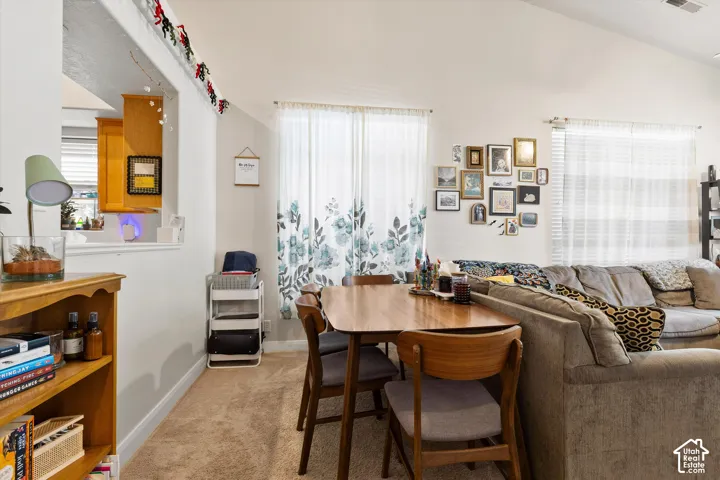 Open-concept living area with vaulted ceilings, recessed lighting, and carpet flooring