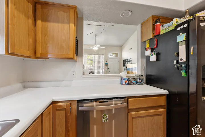 Kitchen featuring wood cabinetry, white countertops, and a stainless steel dishwasher