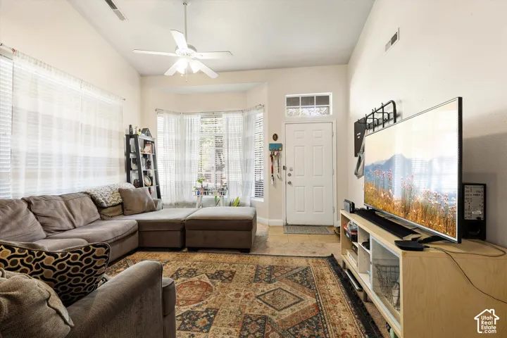 Vaulted ceiling, ceiling fan, bay window, paneled entry door, and transom window
